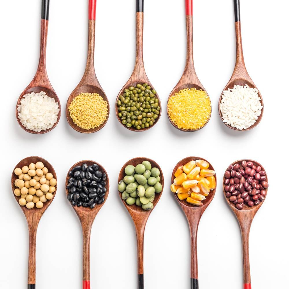 Different whole grains in wooden spoons