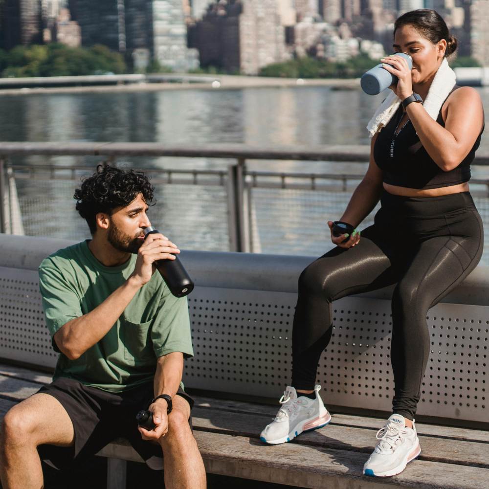 Couple Drinking Water from Bottles after Training