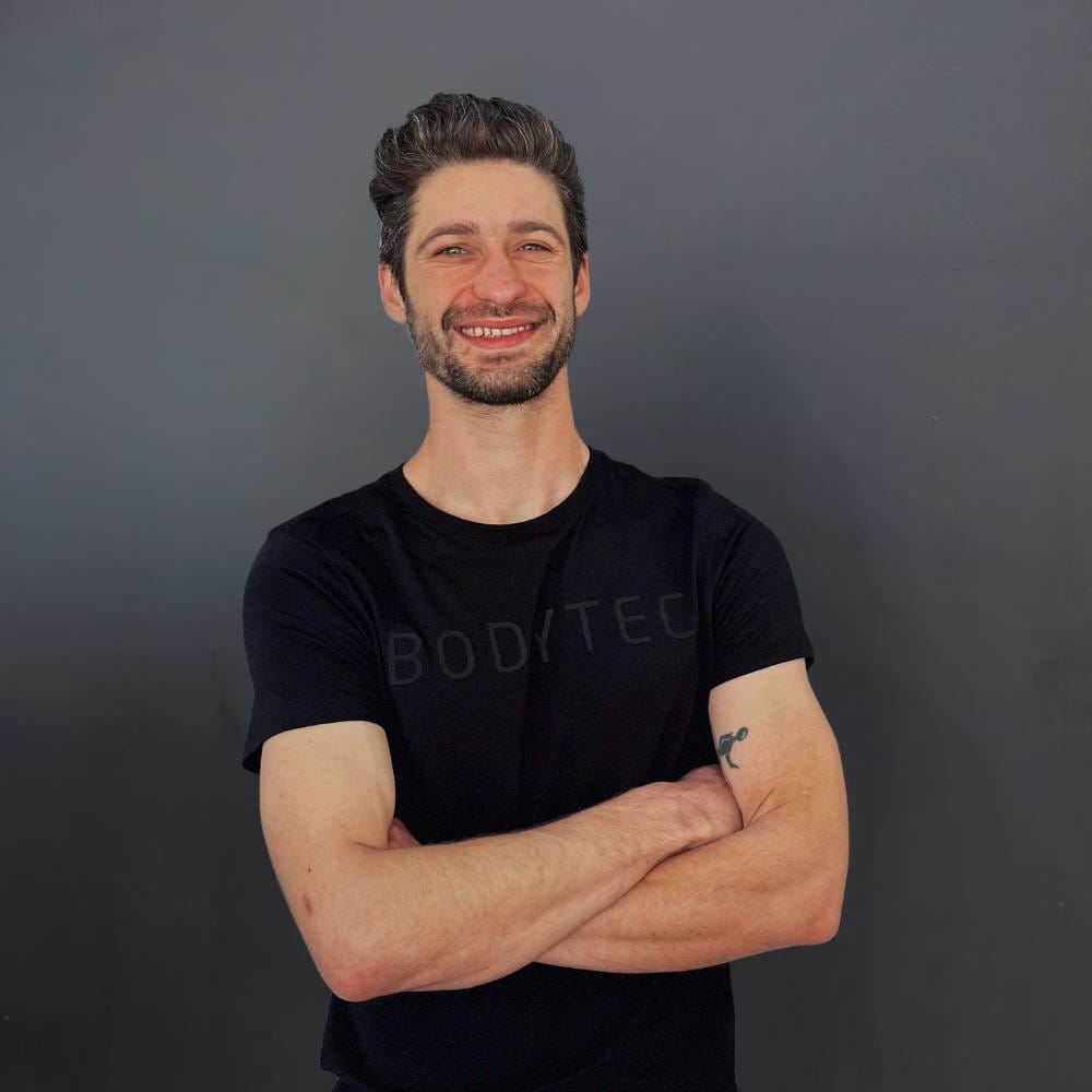 Bernard a studio owner standing in front of a grey wall