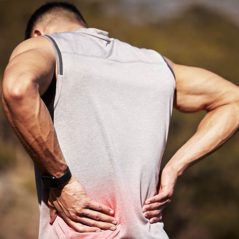 man holding his back which shows inflammation and pain
